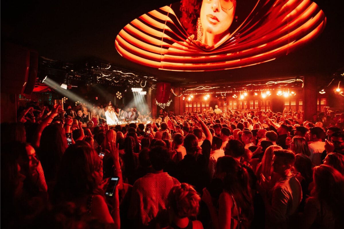 Packed sunken dance floor at Bonbonniere Marbella under a red LED ceiling, DJ playing to the crowd