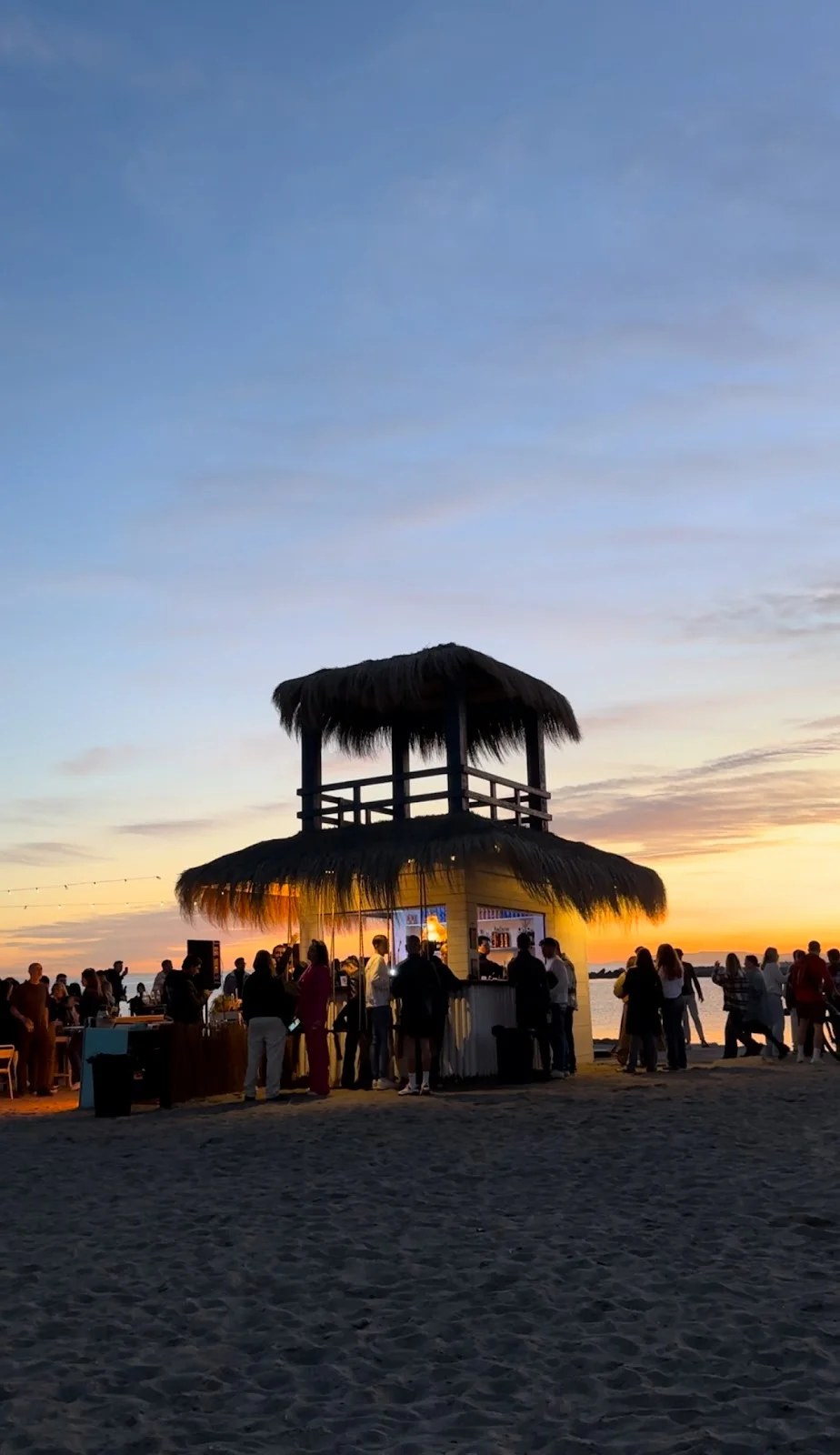 Sunset behind the thatched-roof bar tower at LA SIESTA beach club, Puerto Banús