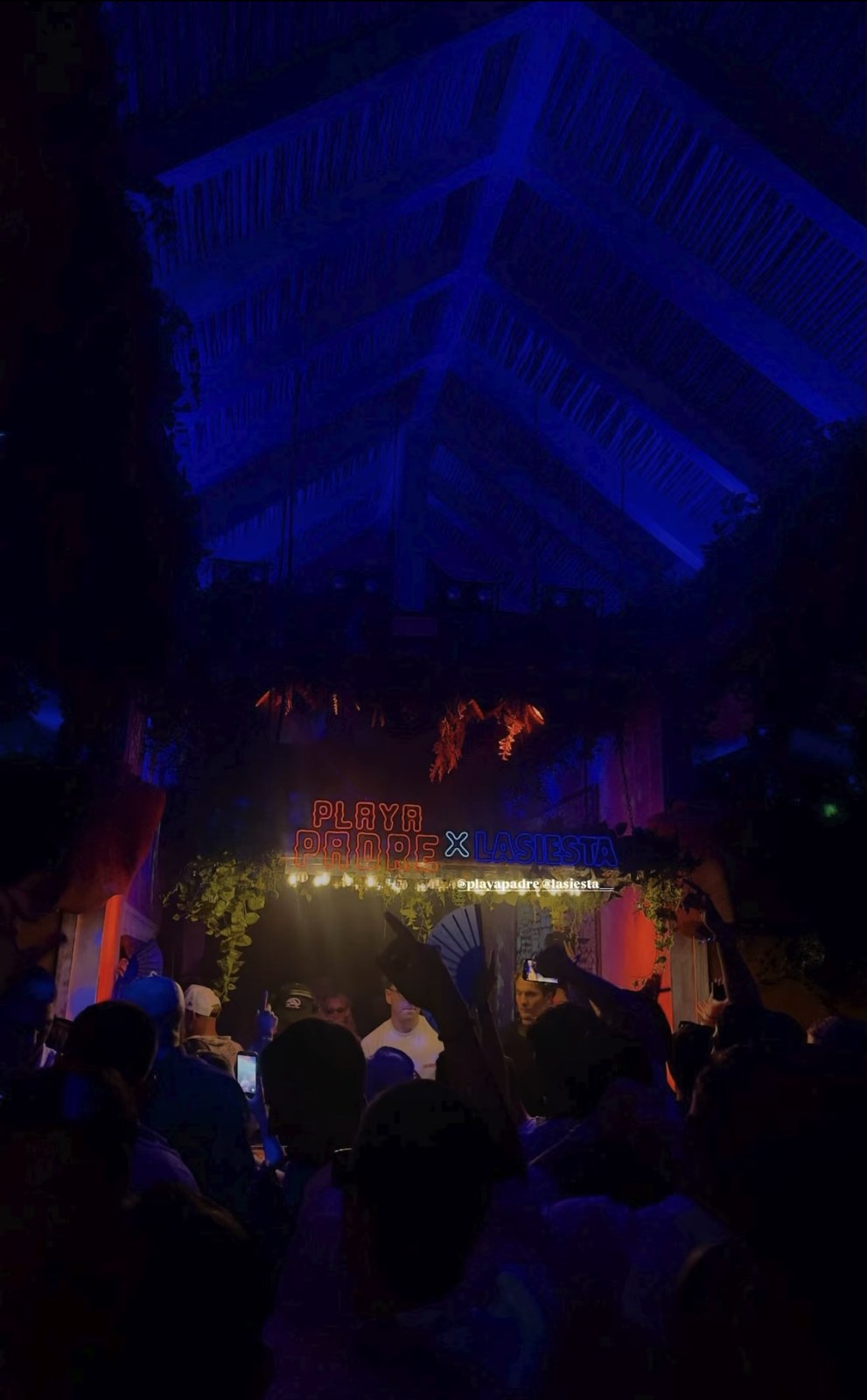 Crowd under the blue-lit thatched roof at a LA SIESTA night event in Puerto Banús